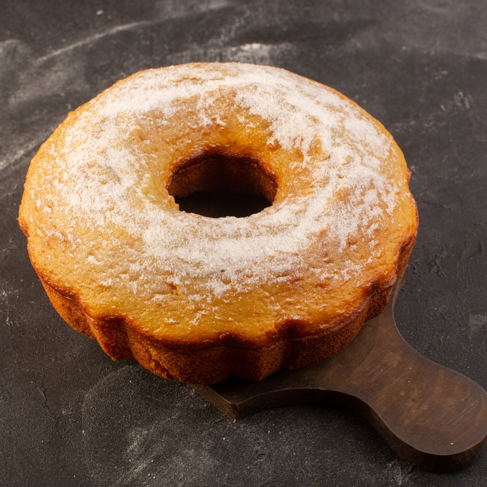 top-view-baked-round-cake-with-sugar-powder-wooden-desk